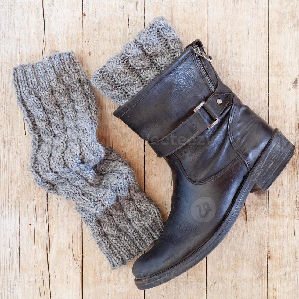 Black leather boot and grey knitted wood legwarmers photo