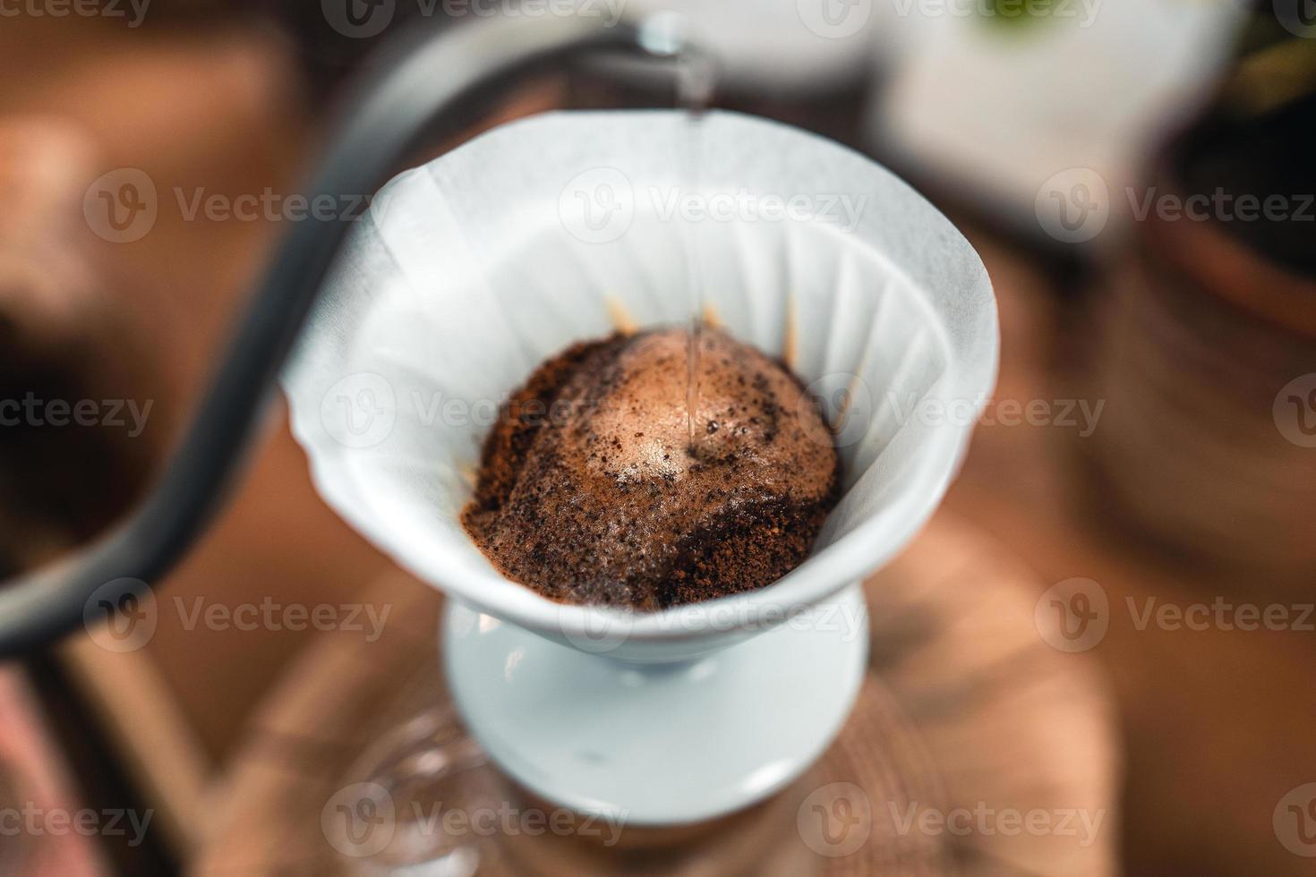 vertiendo agua caliente sobre un café de goteo foto