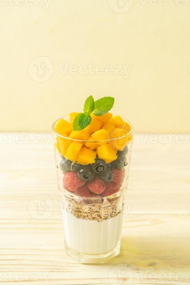 mango, frambuesa y arándano caseros con yogur y granola - estilo de comida saludable foto