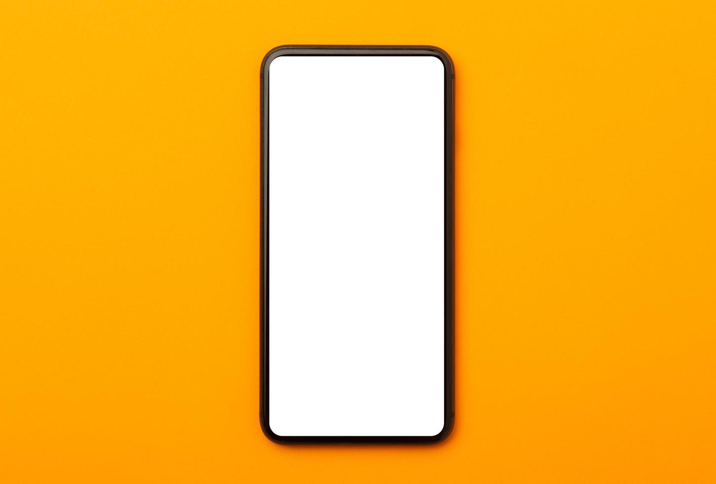 Pantalla en blanco del teléfono inteligente aislada sobre fondo naranja foto
