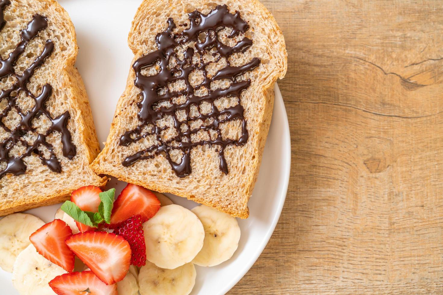 pan integral tostado con plátano fresco, fresa y chocolate para el desayuno foto