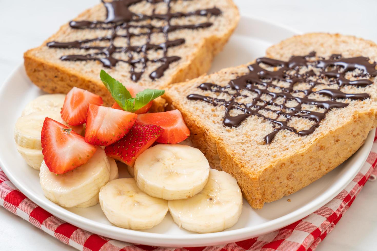 Whole wheat bread toasted with fresh banana, strawberry, and chocolate for breakfast photo