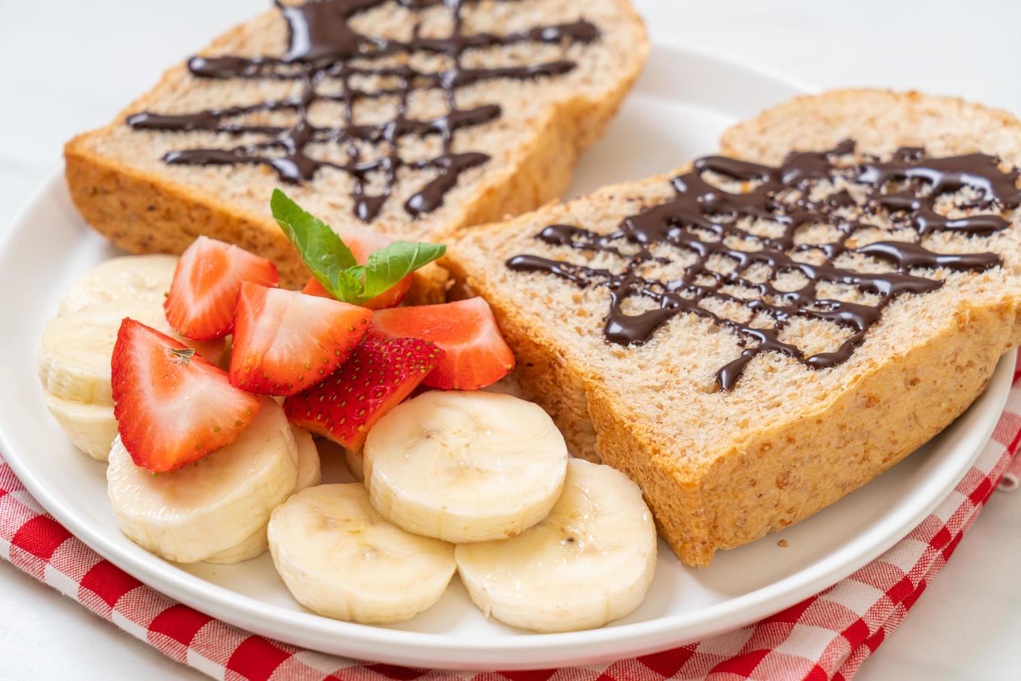 pan integral tostado con plátano fresco, fresa y chocolate para el desayuno foto