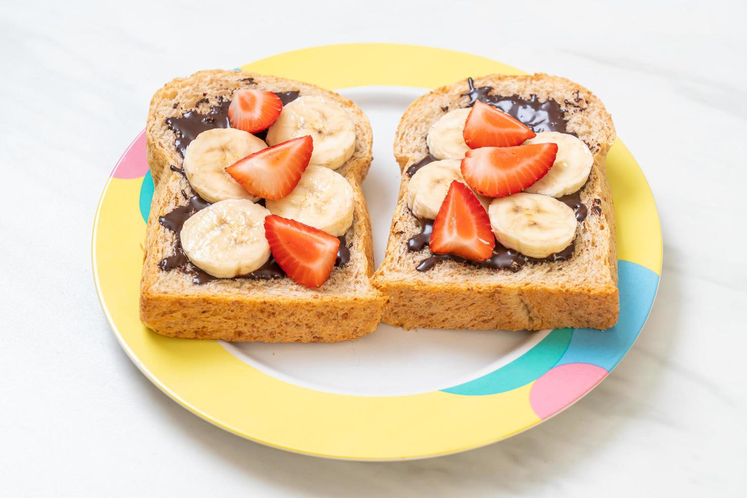 pan integral tostado con plátano fresco, fresa y chocolate para el desayuno foto