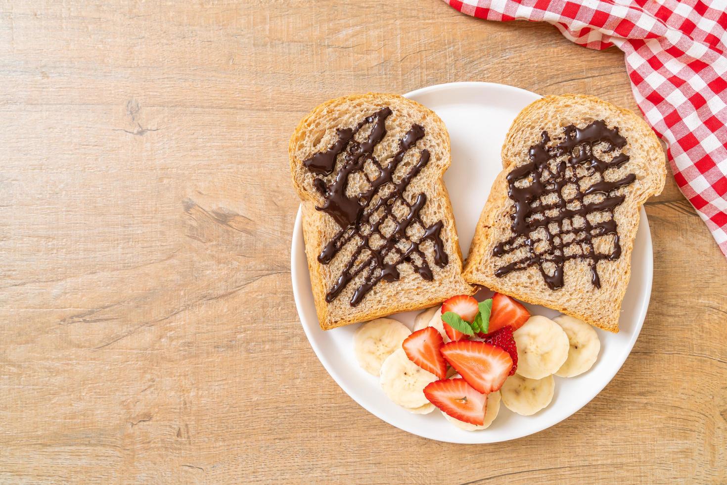 Whole wheat bread toasted with fresh banana, strawberry, and chocolate for breakfast photo