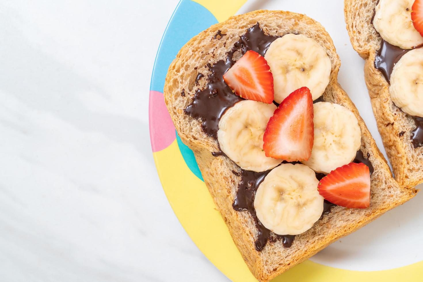 pan integral tostado con plátano fresco, fresa y chocolate para el desayuno foto