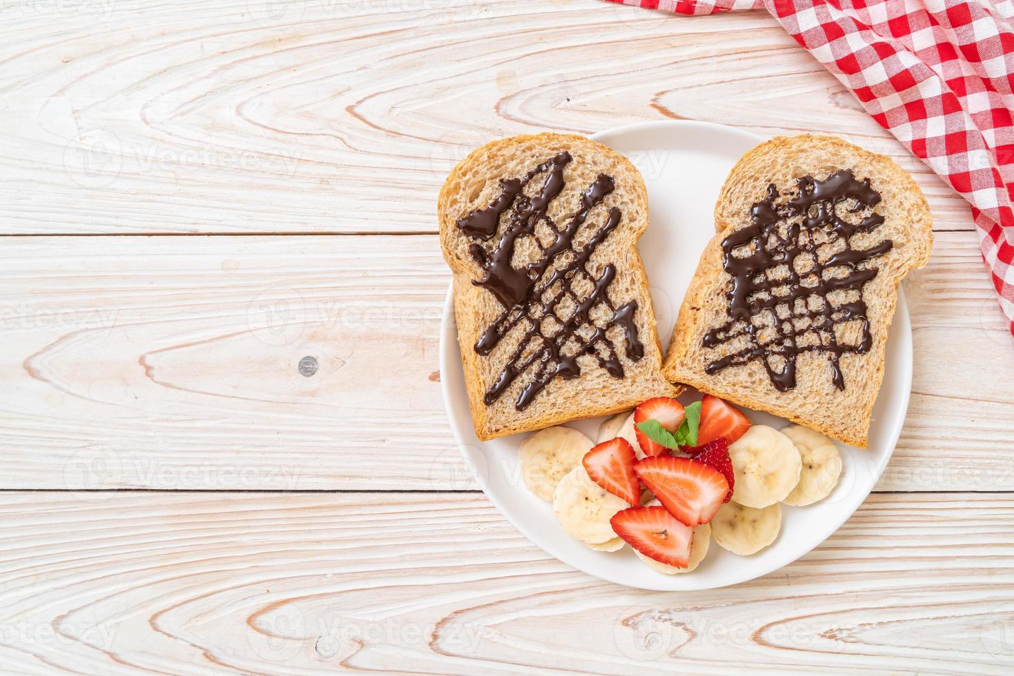 Whole wheat bread toasted with fresh banana, strawberry, and chocolate for breakfast photo