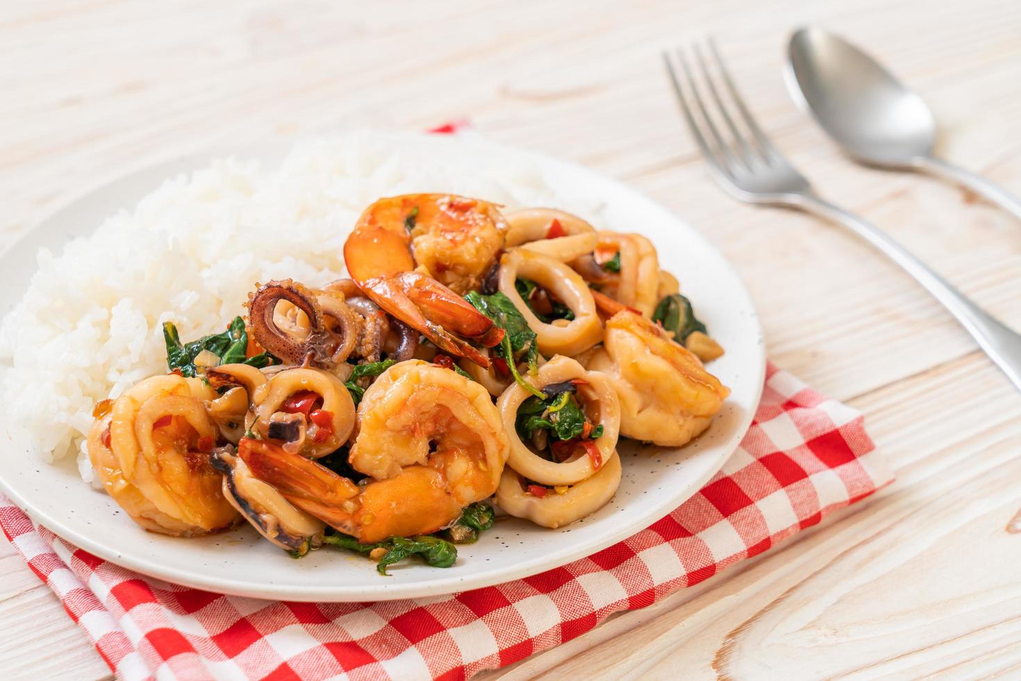 arroz y mariscos salteados de camarones y calamares con albahaca tailandesa - estilo de comida asiática foto