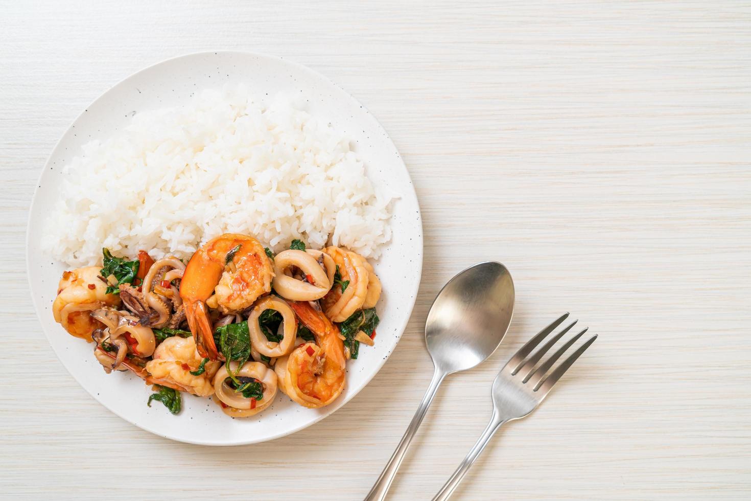 arroz y mariscos salteados de camarones y calamares con albahaca tailandesa - estilo de comida asiática foto
