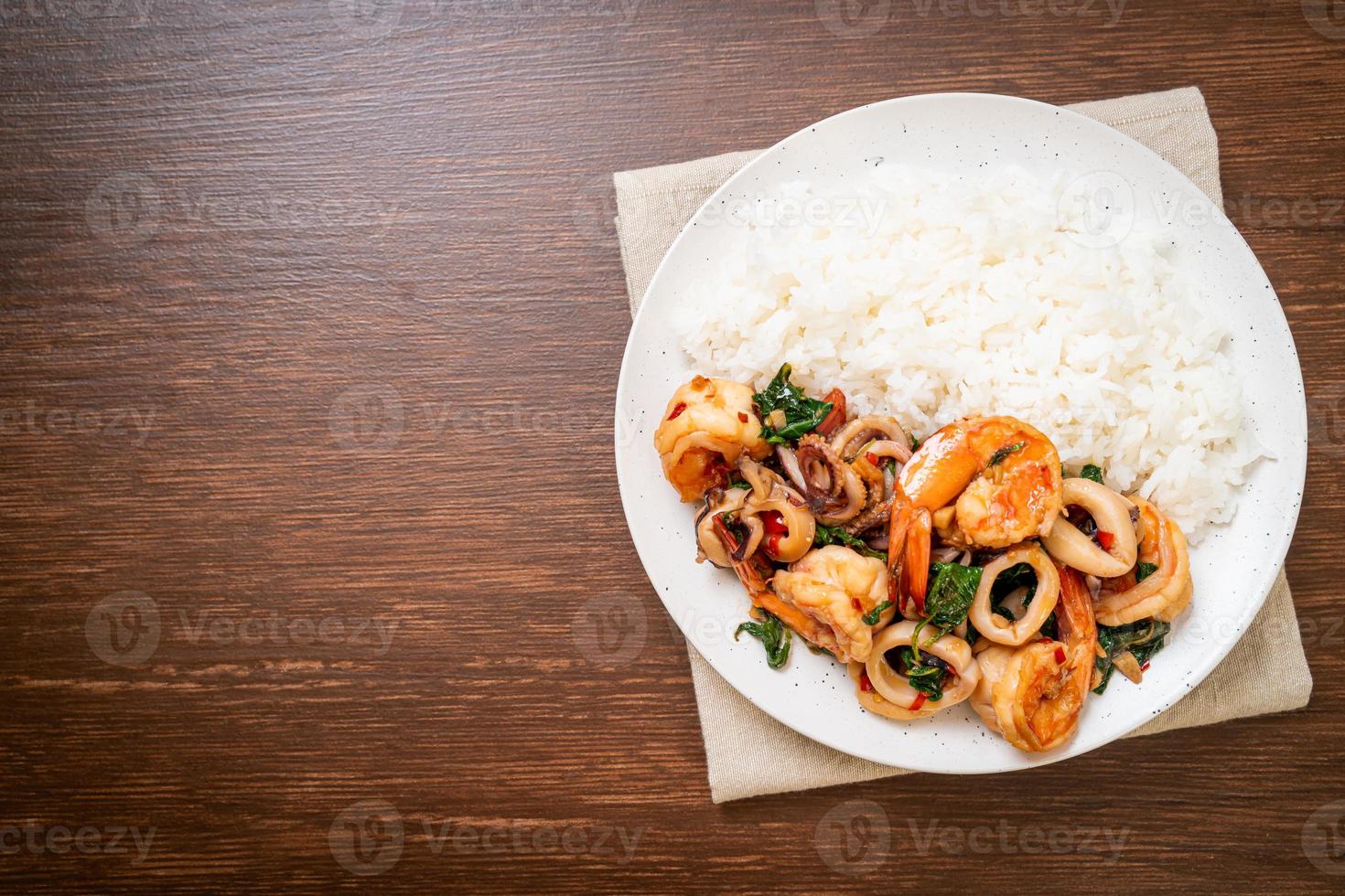 arroz y mariscos salteados de camarones y calamares con albahaca tailandesa - estilo de comida asiática foto