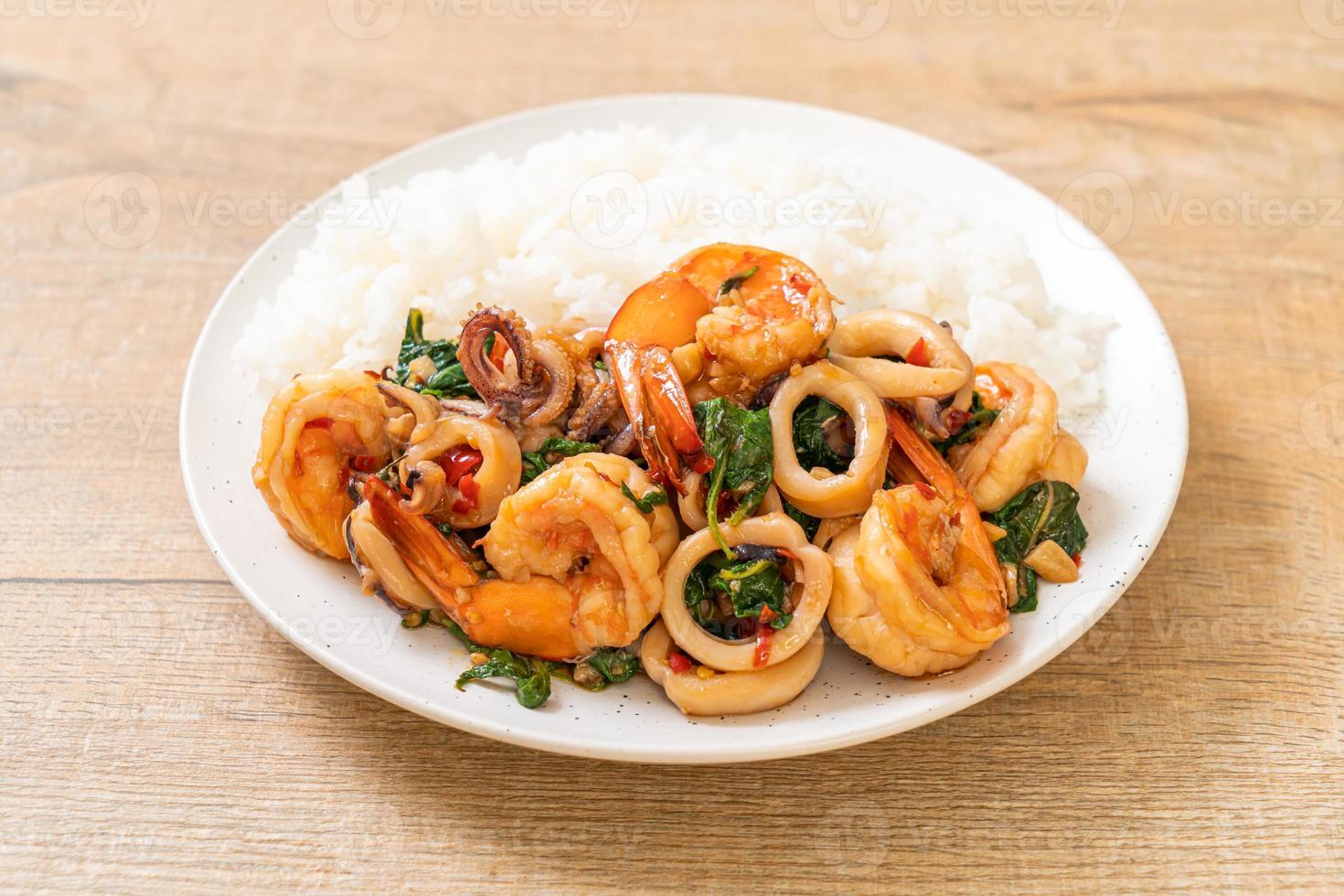 arroz y mariscos salteados de camarones y calamares con albahaca tailandesa - estilo de comida asiática foto