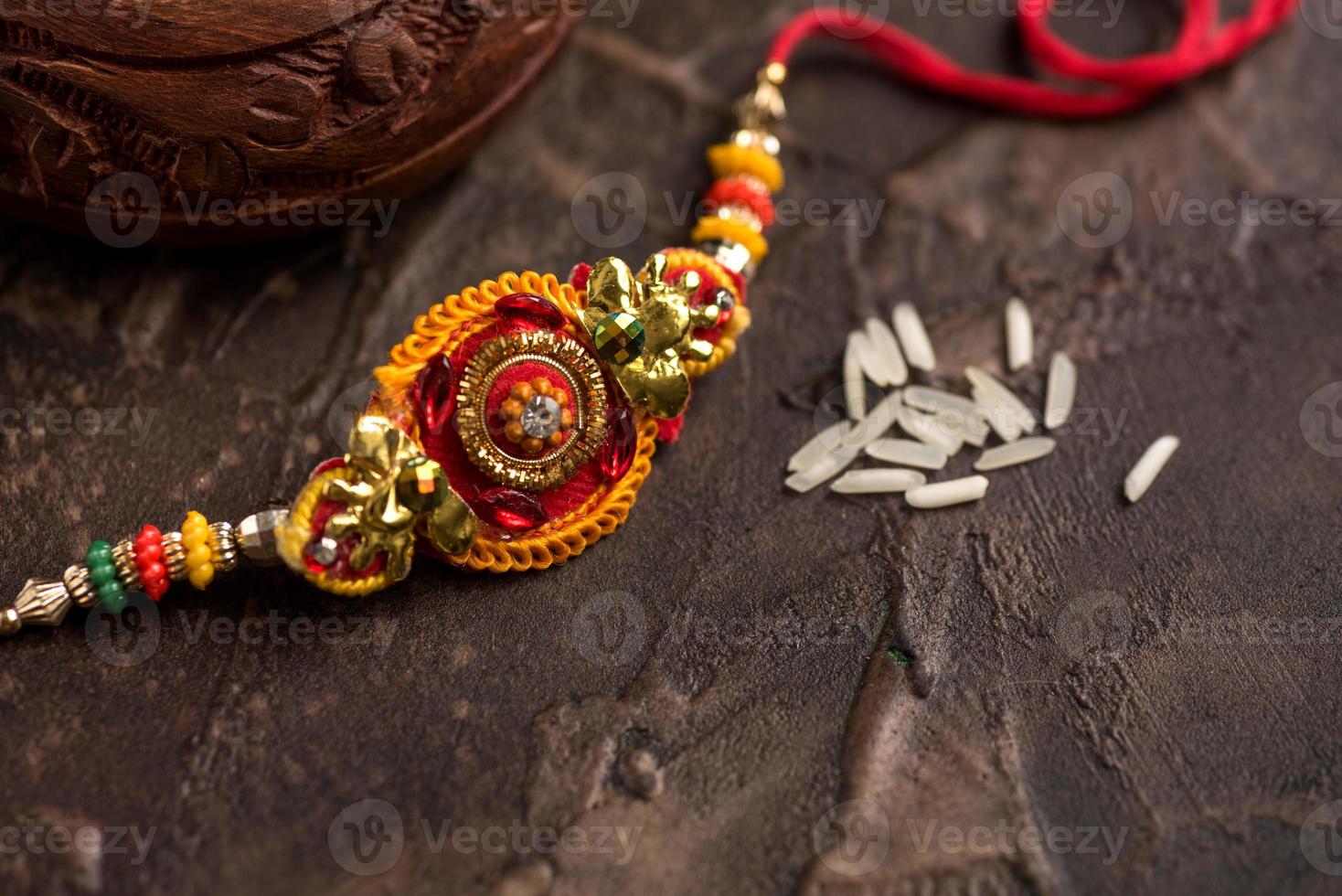 Fondo raksha bandhan con un elegante rakhi y arroz esparcido. una pulsera tradicional india que es un símbolo del amor entre hermanos y hermanas. foto