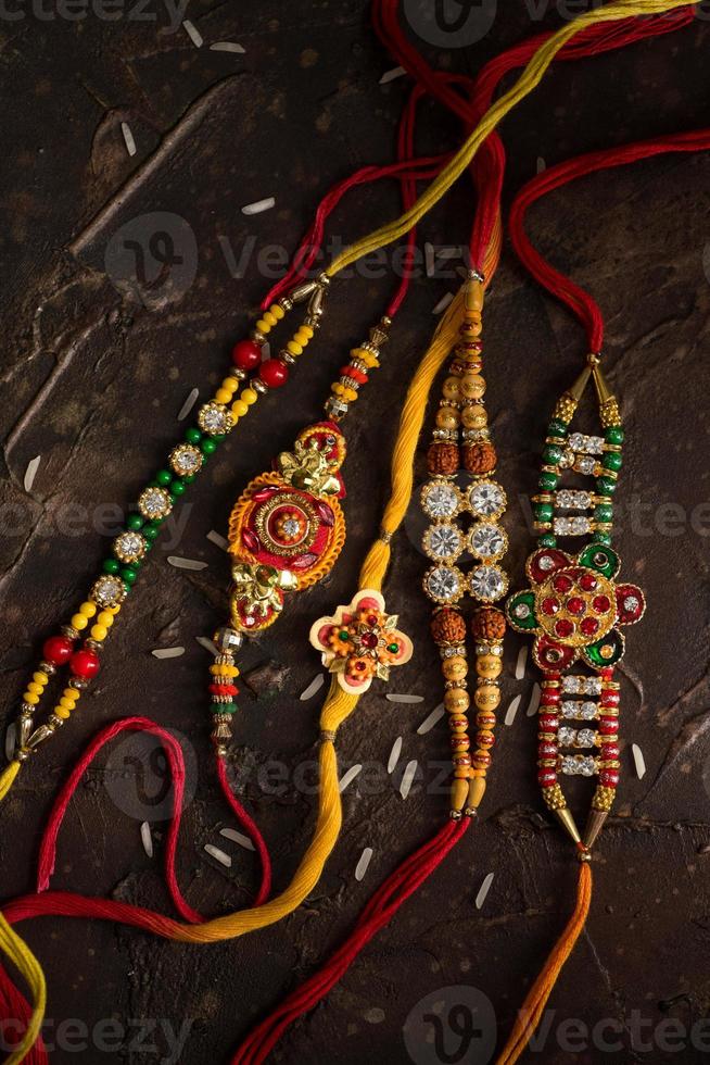 Raksha Bandhan background with an elegant Rakhi and scattered rice. A traditional Indian wrist band which is a symbol of love between Brothers and Sisters. photo