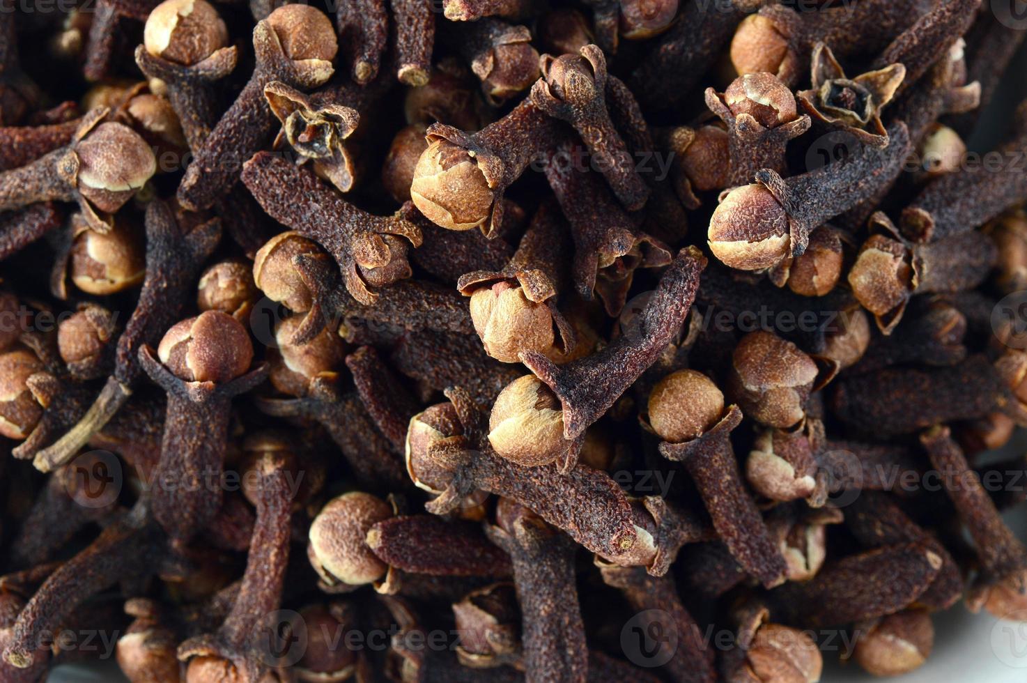 Cloves in plate isolated on white background photo