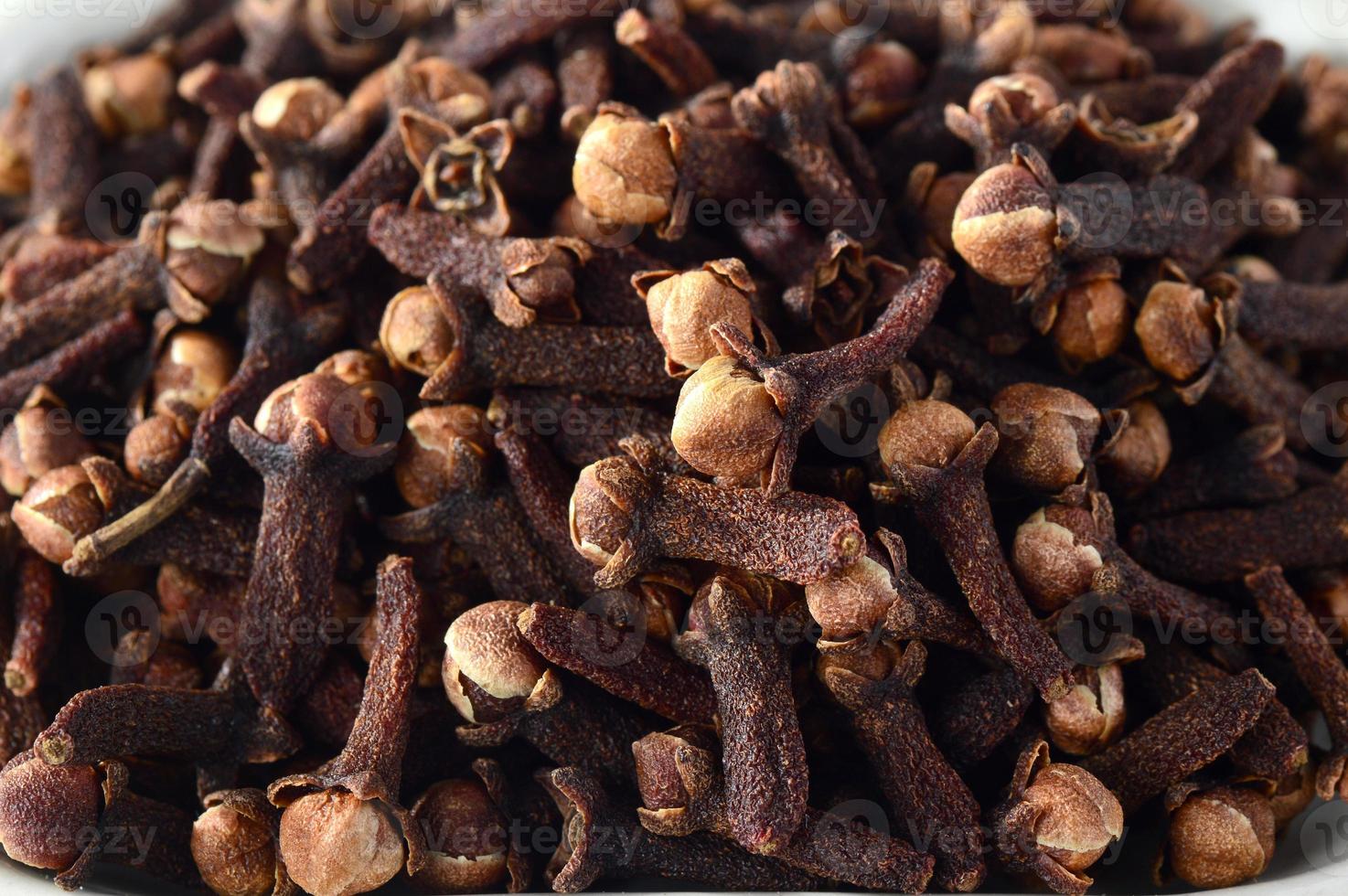 Cloves in plate isolated on white background photo