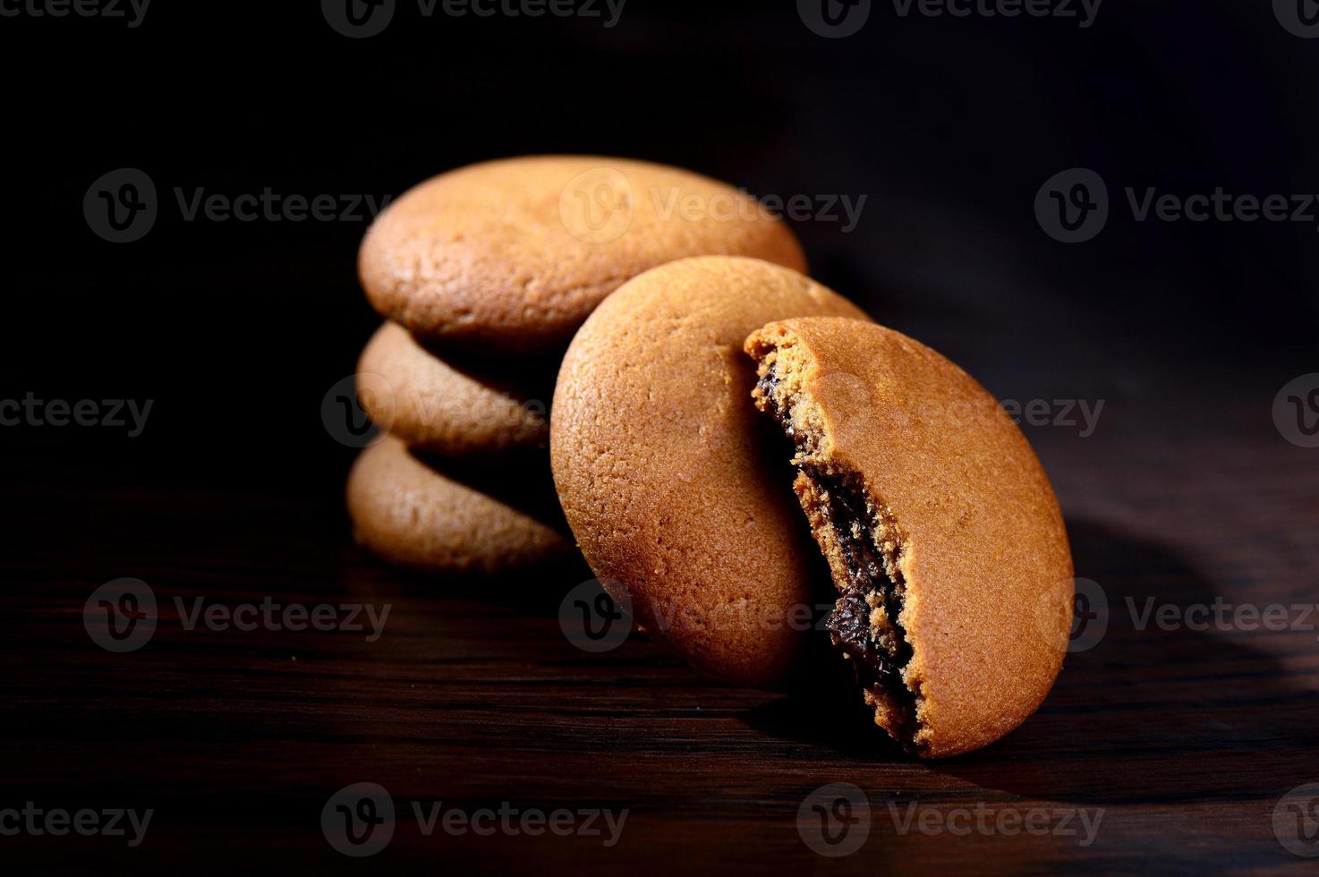 galletas rellenas de crema de chocolate. galletas de crema de chocolate. Galletas de chocolate marrón con relleno de crema sobre fondo negro. foto