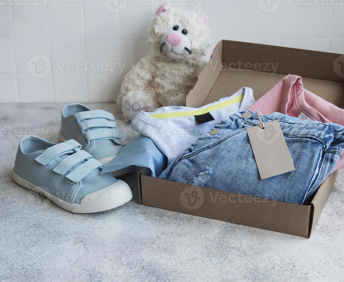 Clothes fir kids in an open cardboard box photo