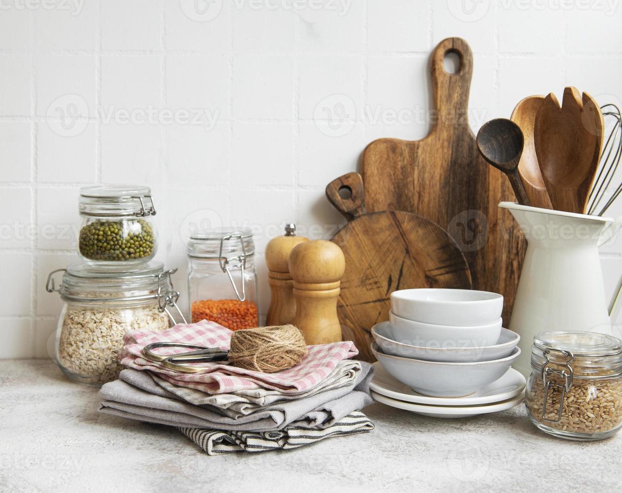 Kitchen utensils, tools and dishware on on the background white tile wall. photo