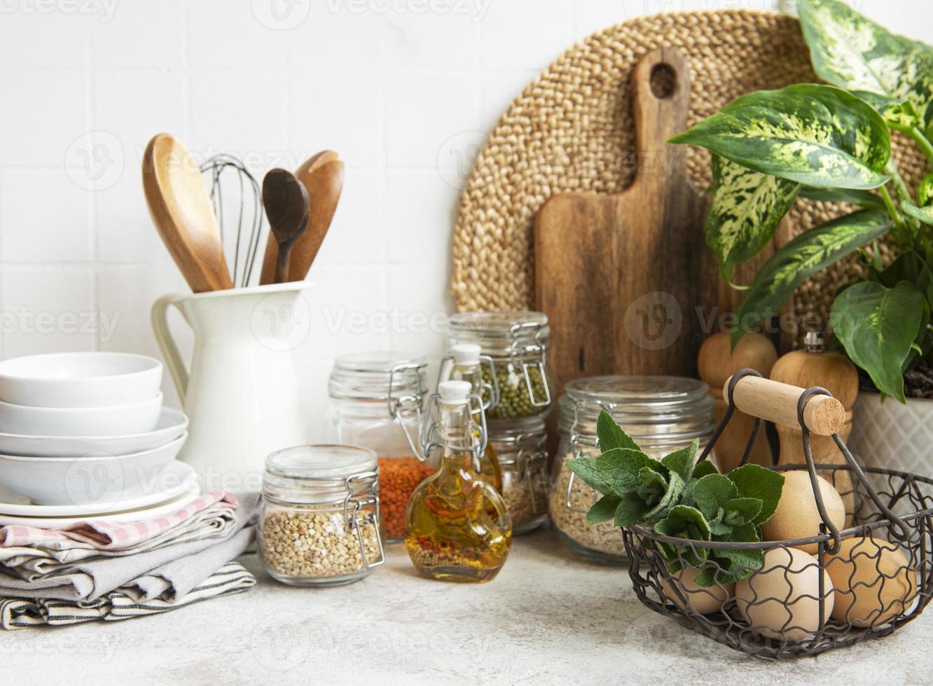 Kitchen utensils, tools and dishware on on the background white tile wall. photo