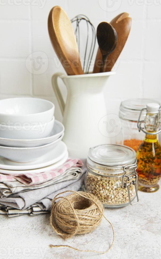 Kitchen utensils, tools and dishware on on the background white tile wall. photo