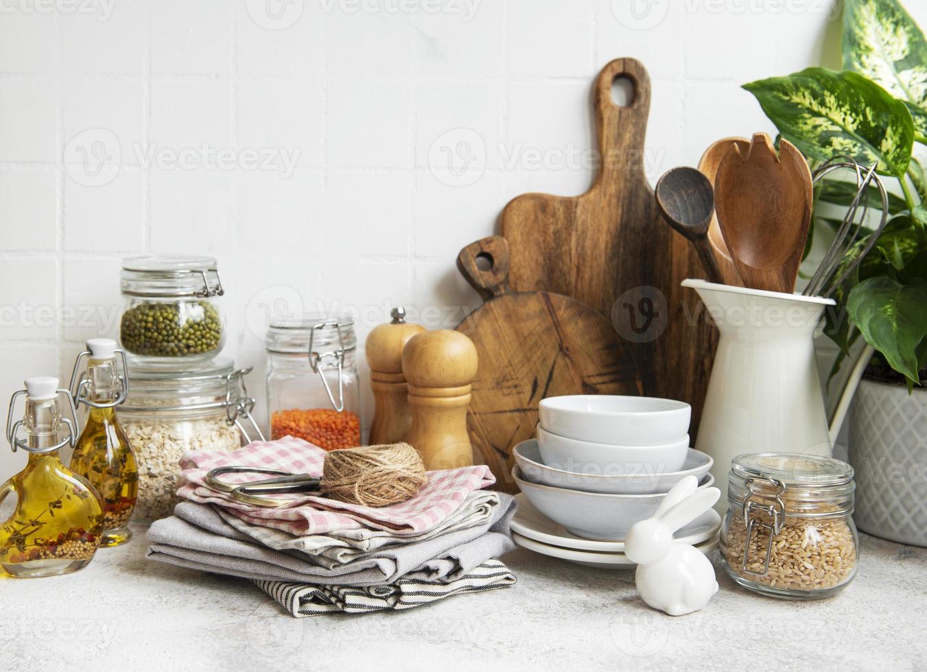 Kitchen utensils, tools and dishware on on the background white tile wall. photo