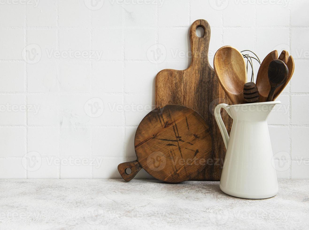 utensilios de cocina, herramientas y vajilla en la pared de azulejos blancos de fondo. foto