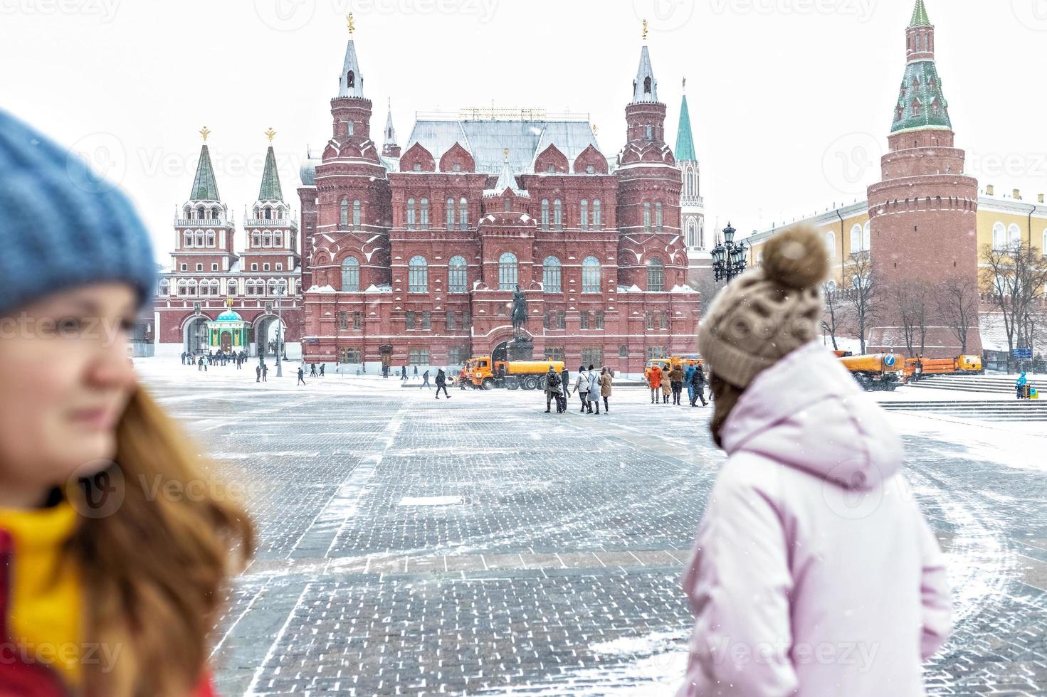 A beautiful young girls walks along Manezhnaya Square in Moscow during a snowfall and blizzard photo