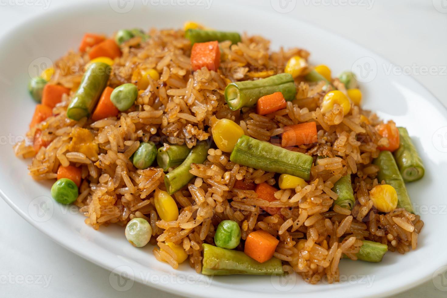 arroz frito con guisantes, zanahorias y maíz - estilo de comida vegetariana y saludable foto