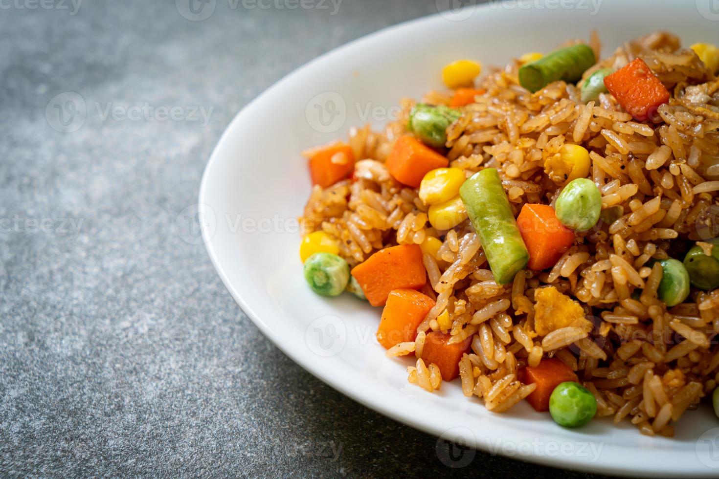 arroz frito con guisantes, zanahorias y maíz - estilo de comida vegetariana y saludable foto