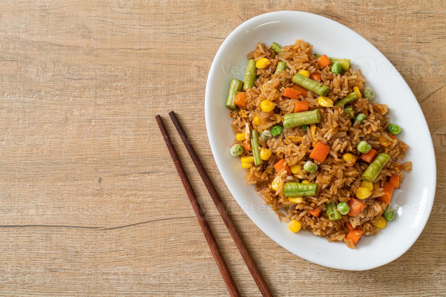 arroz frito con guisantes, zanahorias y maíz - estilo de comida vegetariana y saludable foto