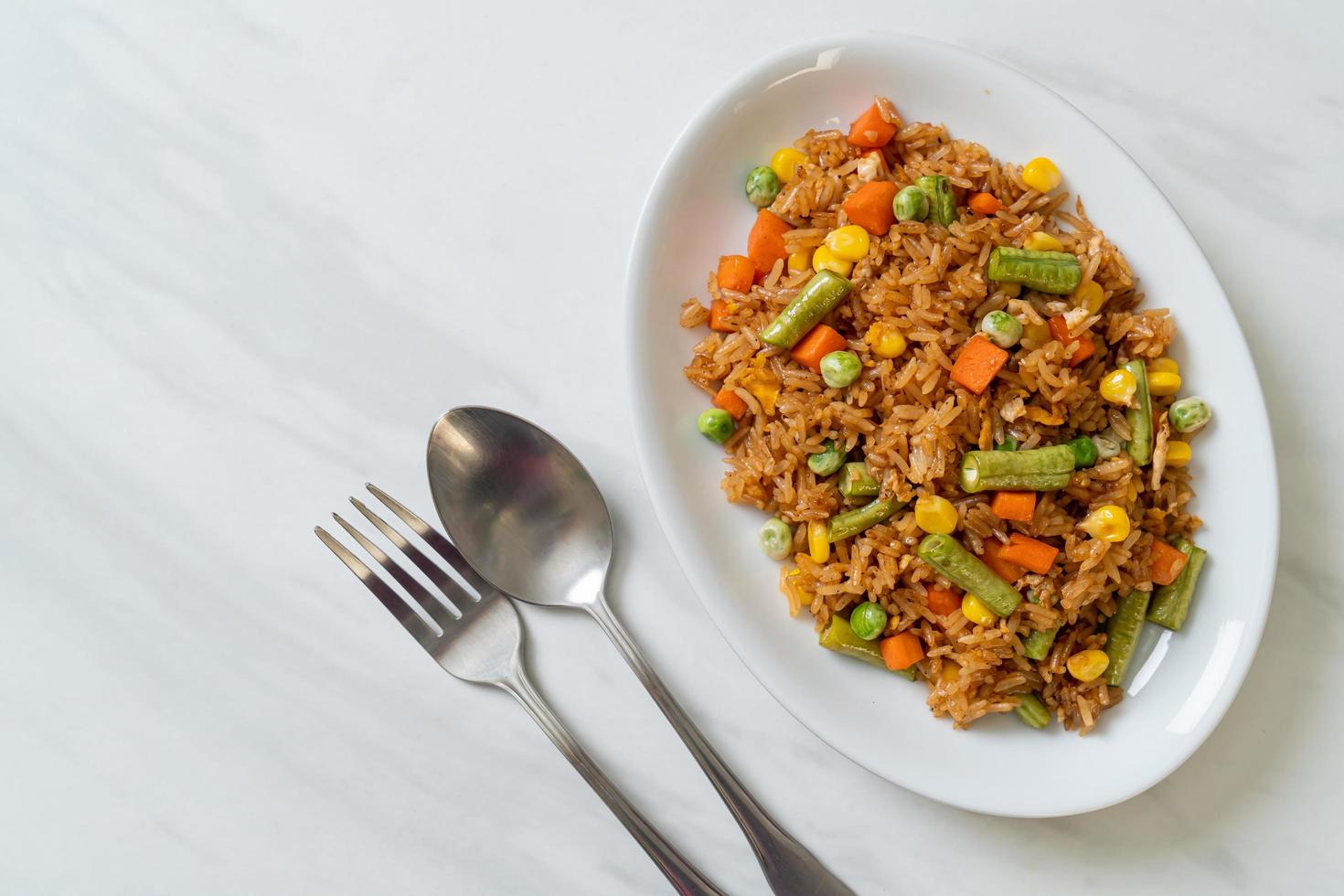 arroz frito con guisantes, zanahorias y maíz - estilo de comida vegetariana y saludable foto