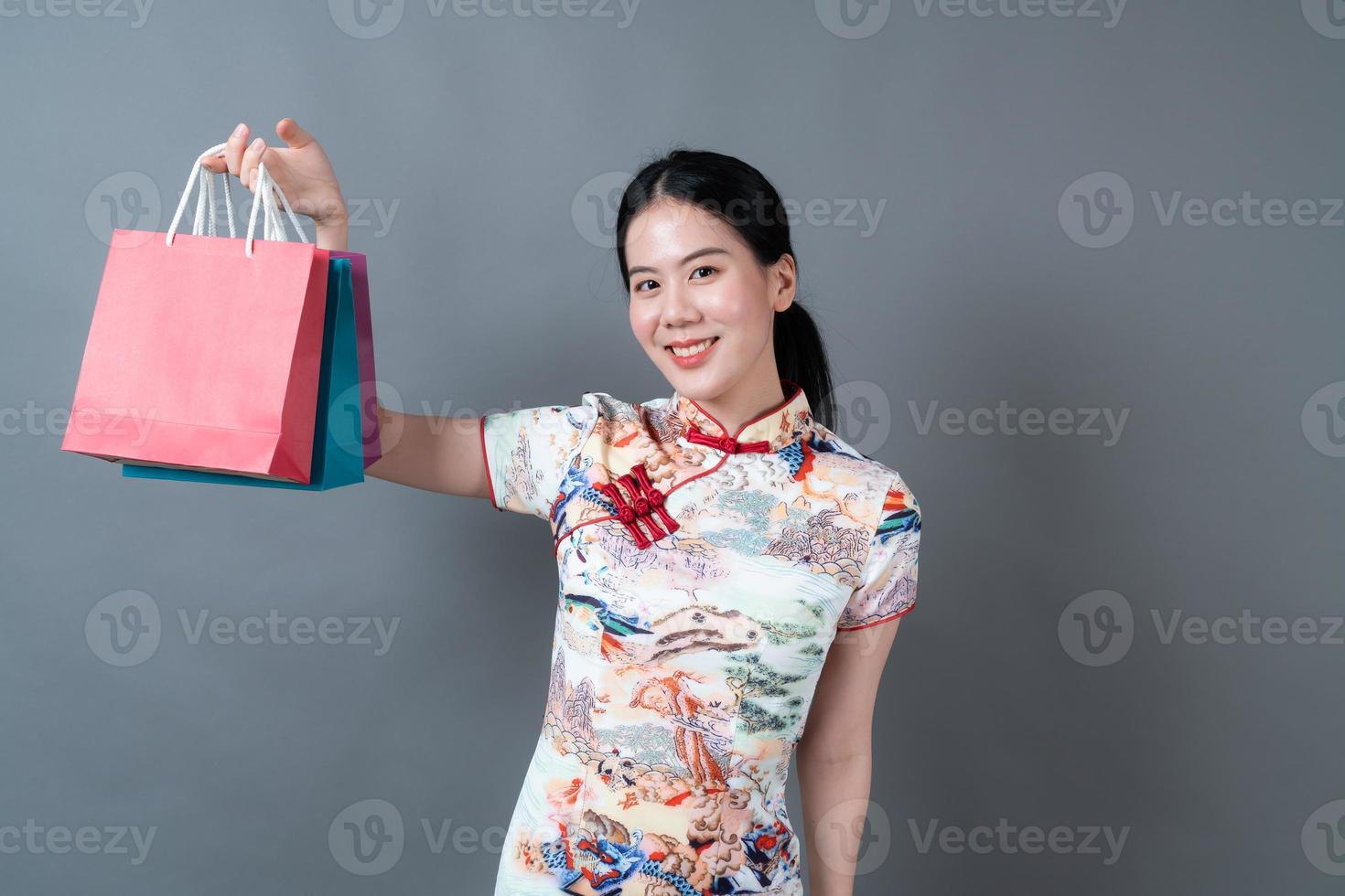 Mujer asiática vistiendo traje tradicional chino con bolsa de compras y tarjeta de crédito foto