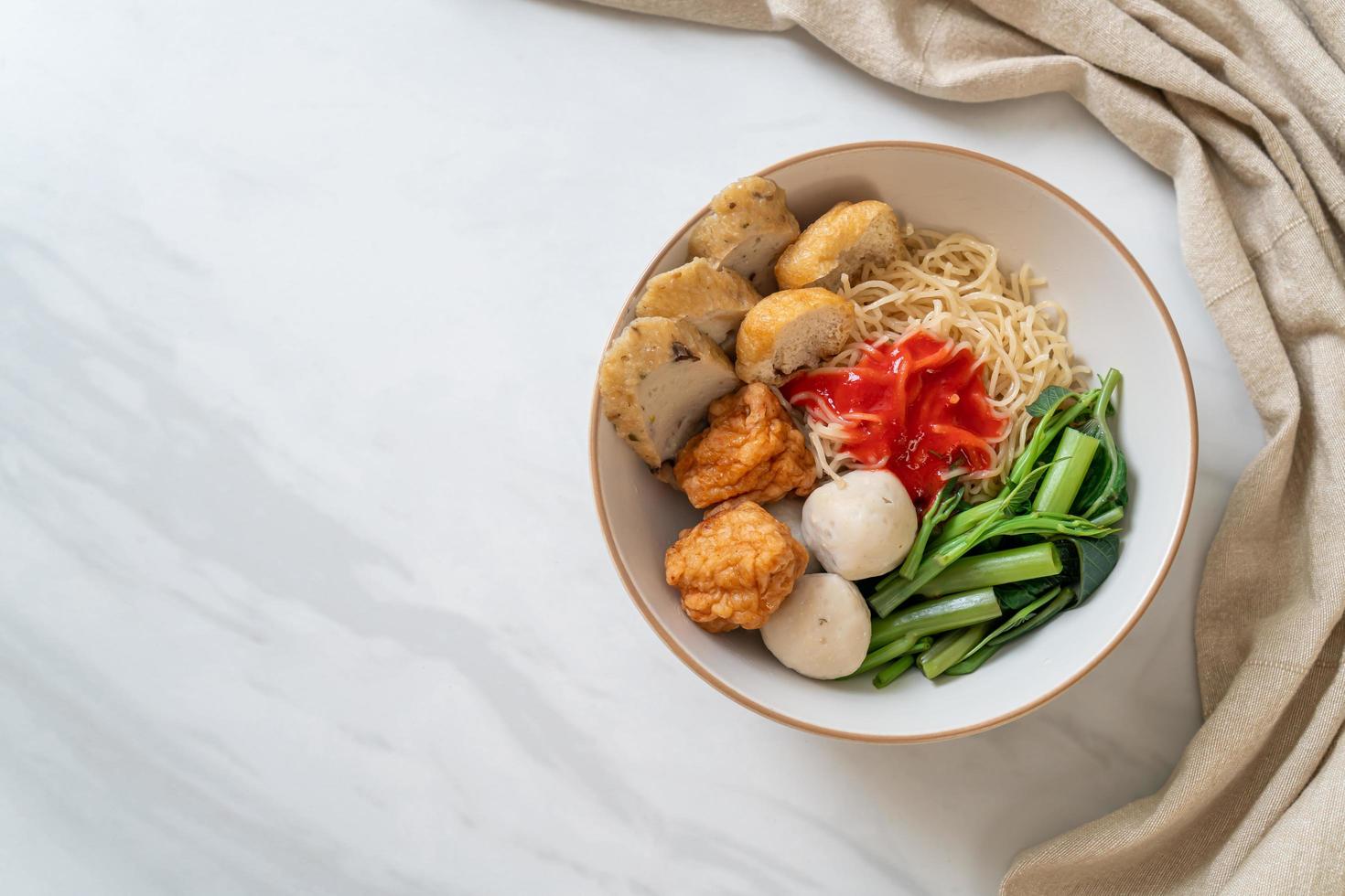 Egg noodles with fish balls and shrimp balls in pink sauce, Yen Ta Four or Yen Ta Fo - Asian food style photo