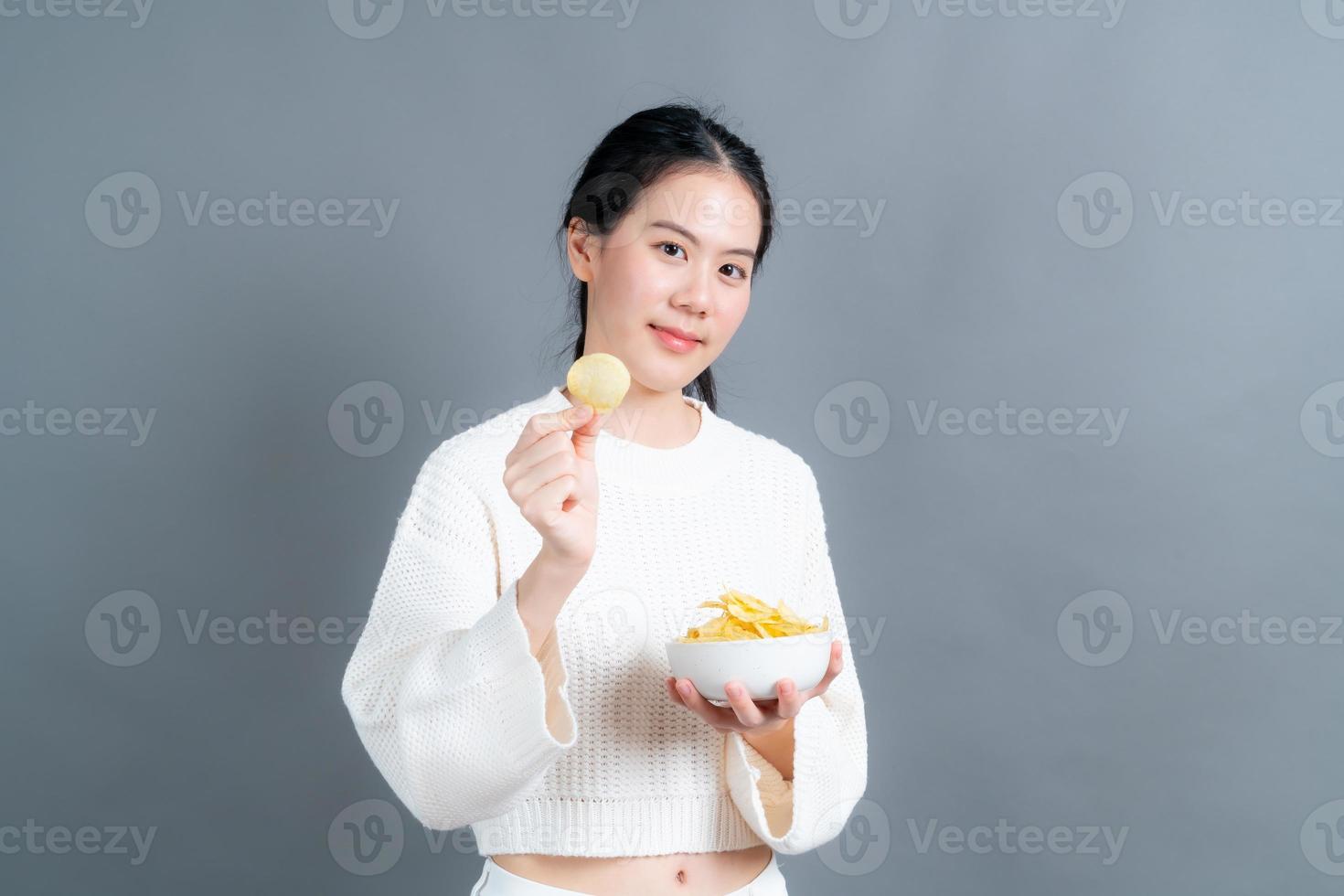 Young Asian woman eat potato chips photo