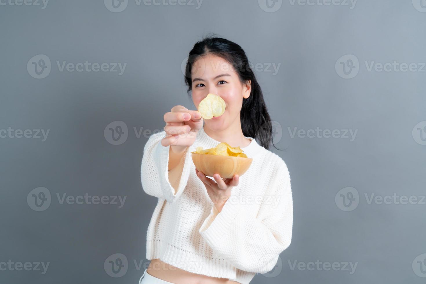 joven asiática comer papas fritas foto