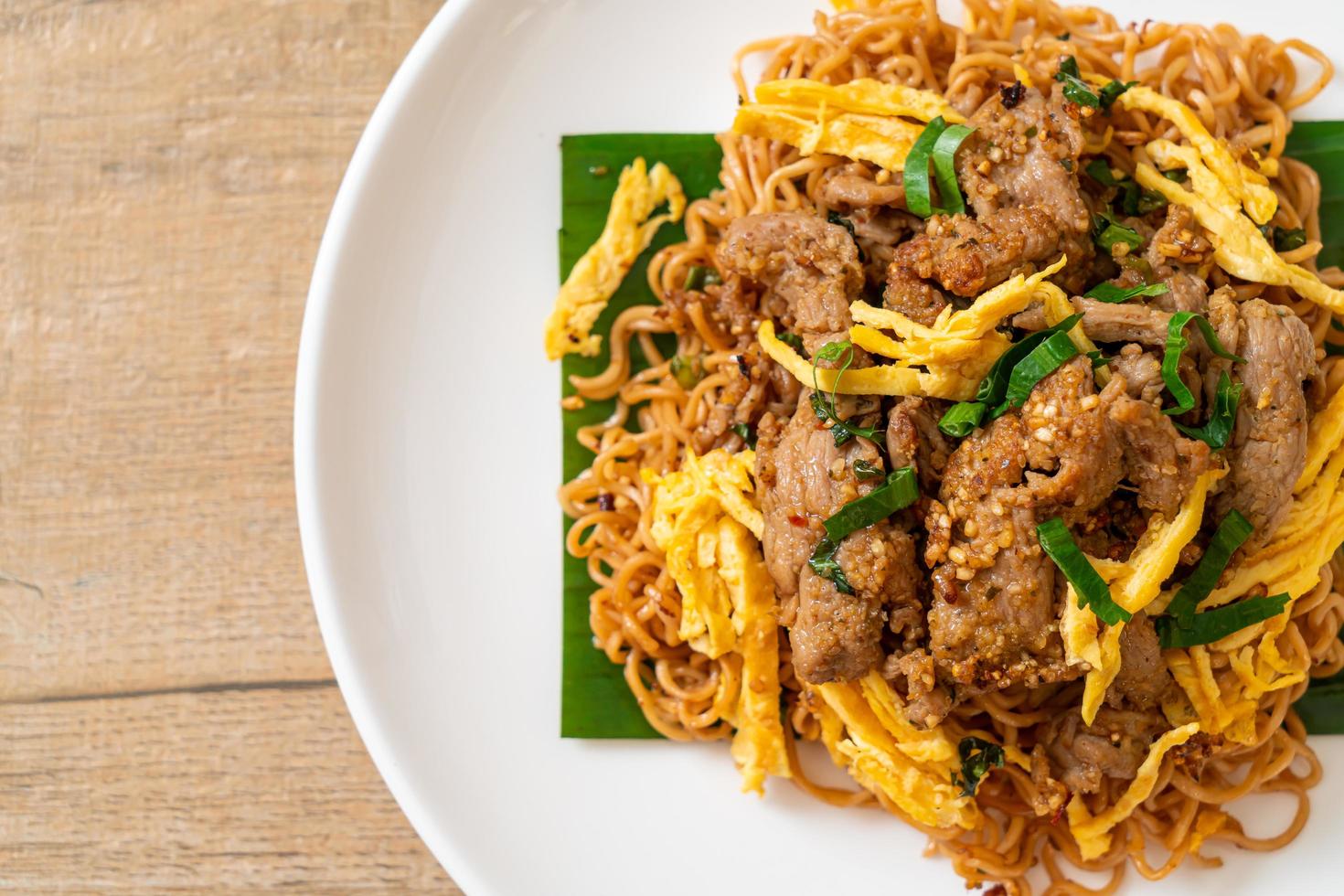 fideos instantáneos salteados con cerdo y huevo - estilo de comida callejera local asiática foto