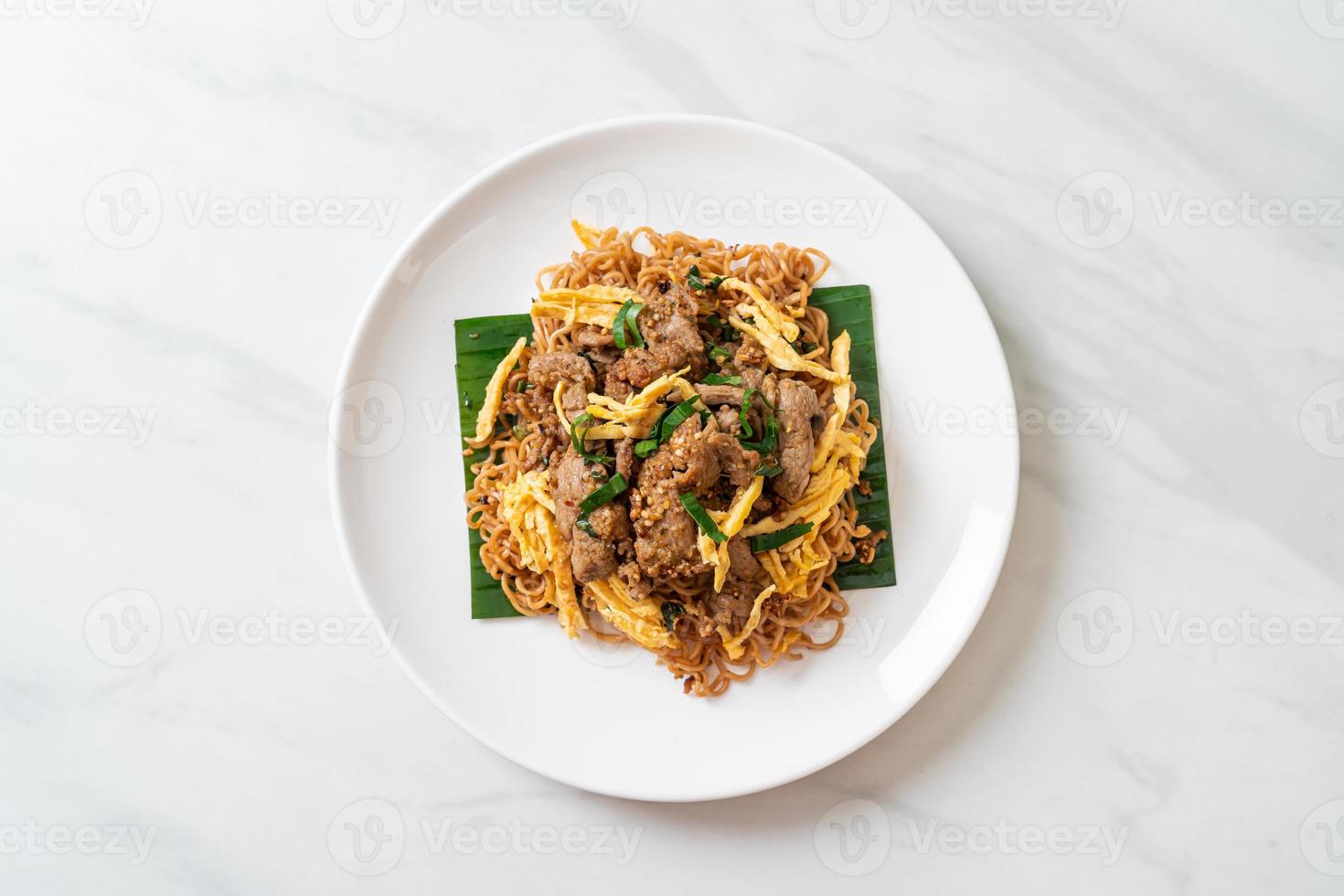 fideos instantáneos salteados con cerdo y huevo - estilo de comida callejera local asiática foto