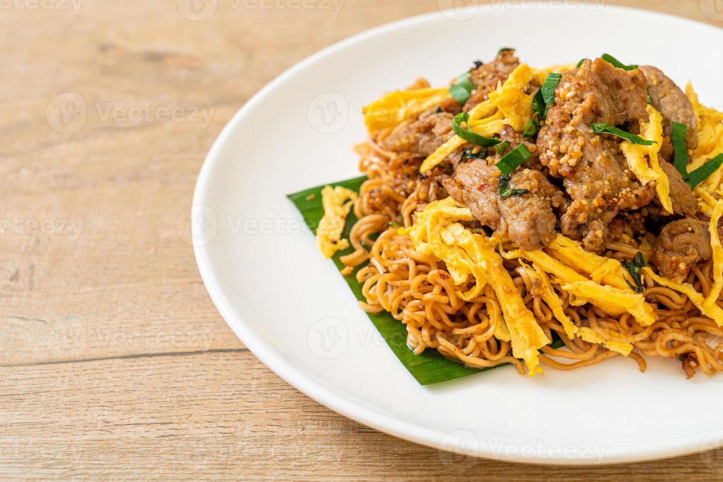 fideos instantáneos salteados con cerdo y huevo - estilo de comida callejera local asiática foto