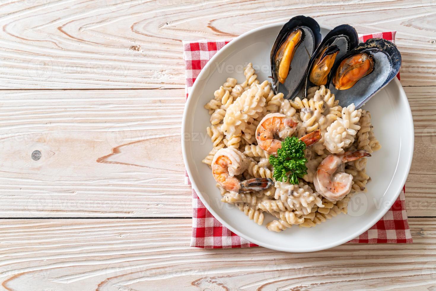 Spiral pasta mushroom cream sauce with seafood - Italian food style photo