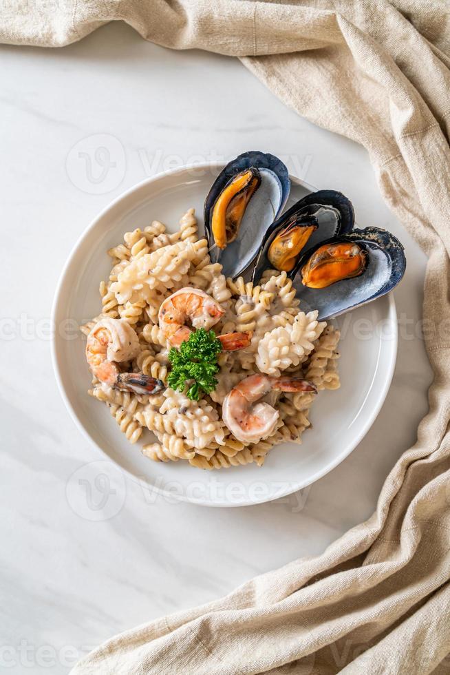 Spiral pasta mushroom cream sauce with seafood - Italian food style photo