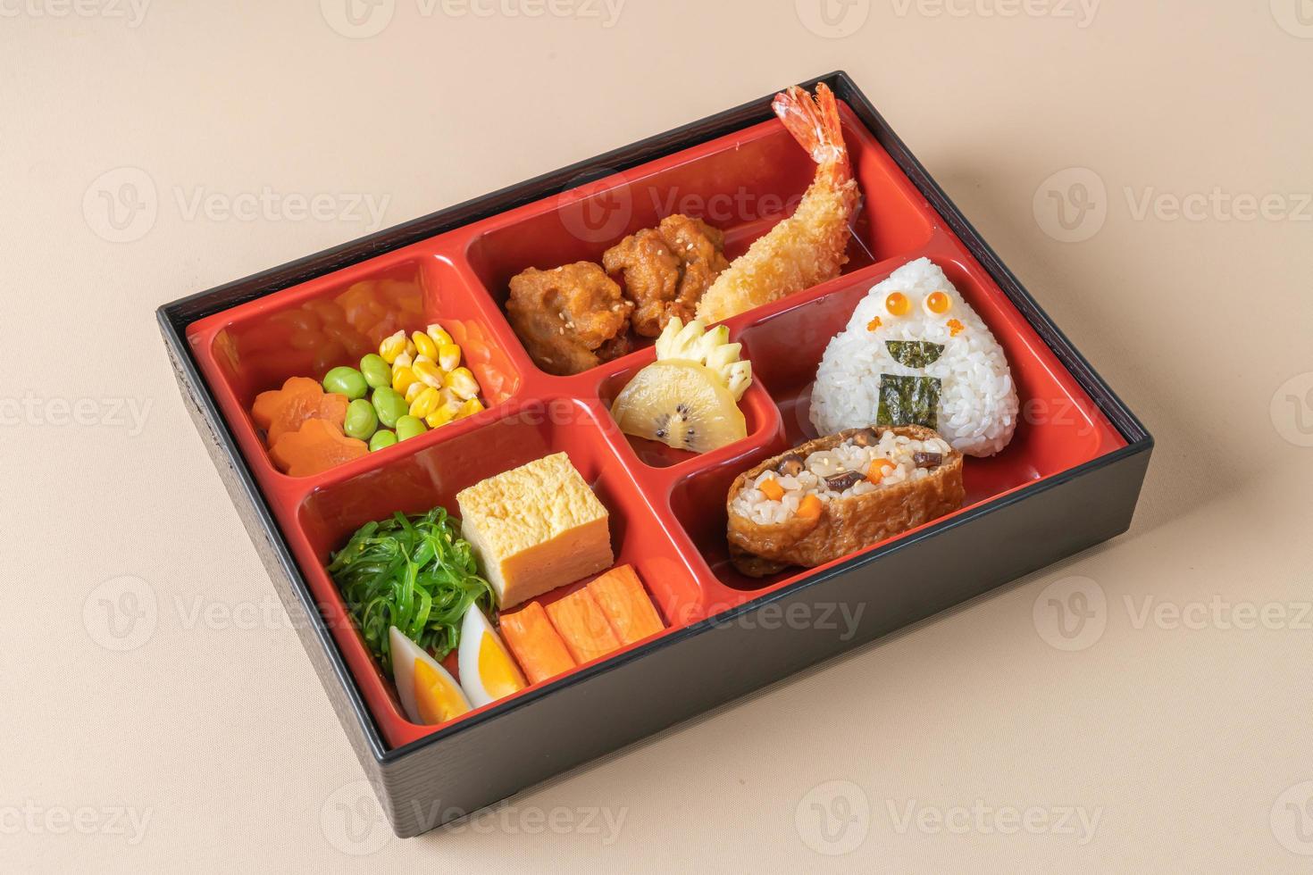 arroz de sushi inari envuelto en tofu seco con camarones fritos y pollo frito en un juego de bento - estilo de comida japonesa foto