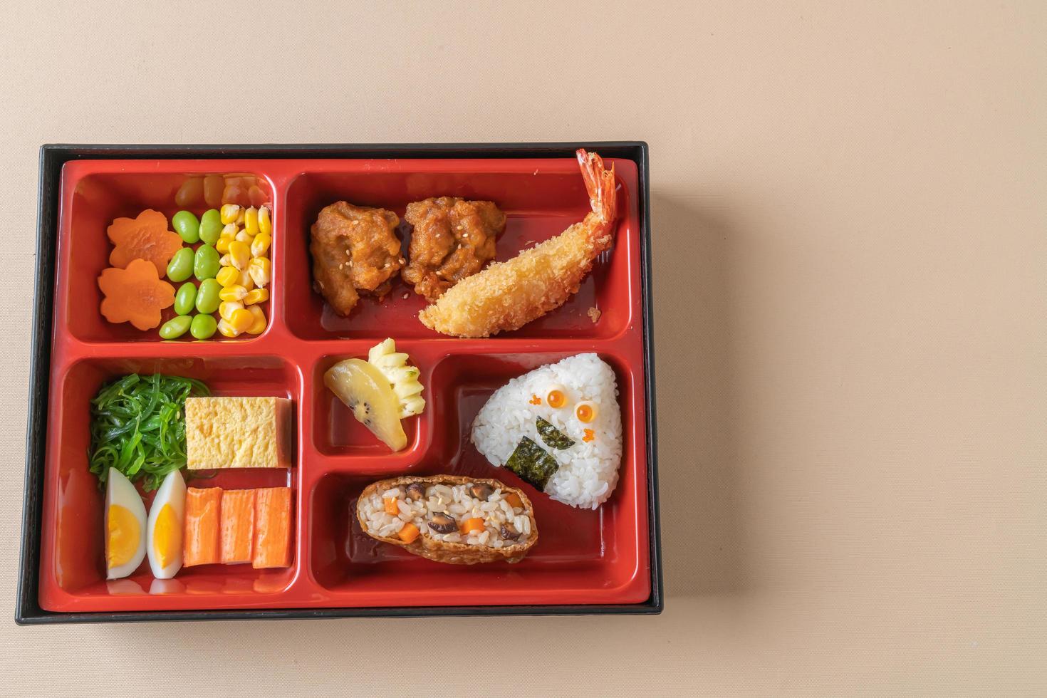 arroz de sushi inari envuelto en tofu seco con camarones fritos y pollo frito en un juego de bento - estilo de comida japonesa foto