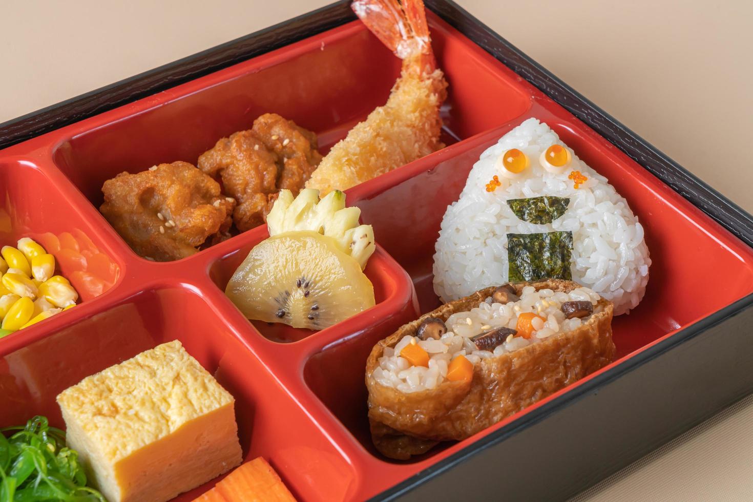 arroz de sushi inari envuelto en tofu seco con camarones fritos y pollo frito en un juego de bento - estilo de comida japonesa foto