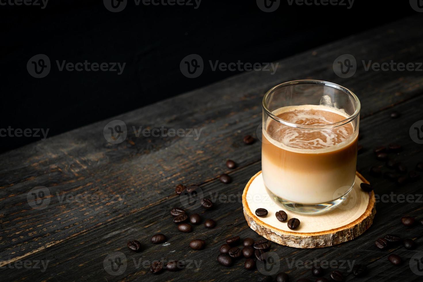 Vaso de café con leche, café con leche sobre fondo de madera foto