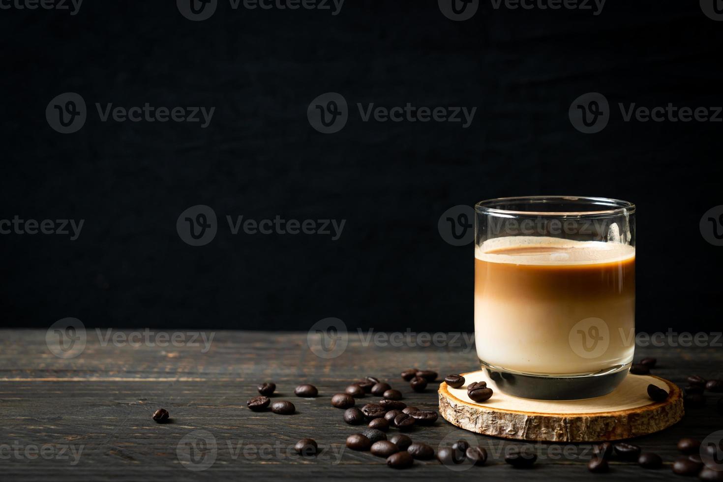 Glass of latte coffee, coffee with milk on wood background photo