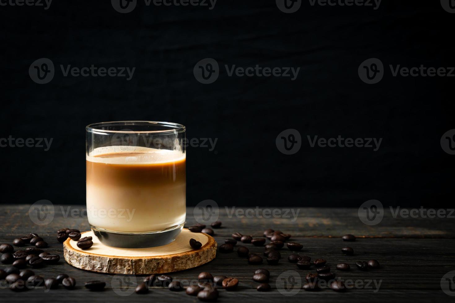 Glass of latte coffee, coffee with milk on wood background photo