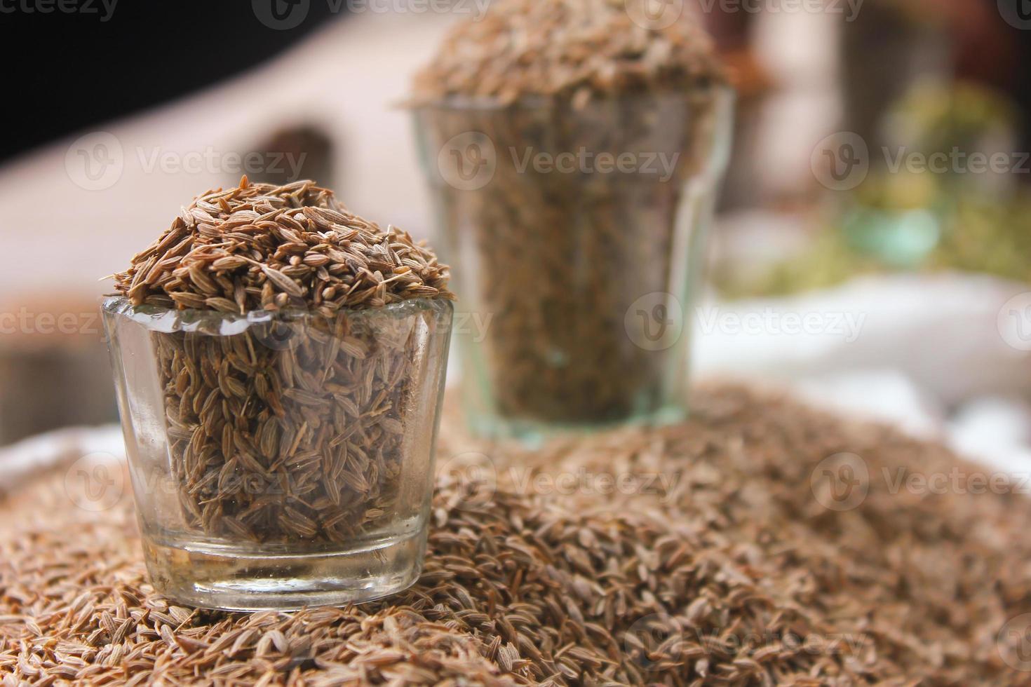 Cumin seeds in glass at local market, Indian spices photo