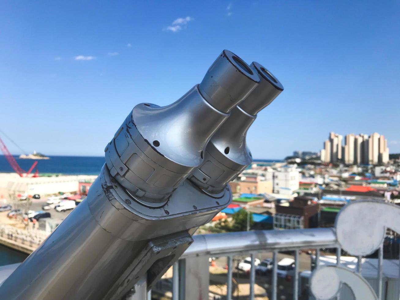 Observation binoculars on the bridge and Sokcho city on the background, South Korea photo