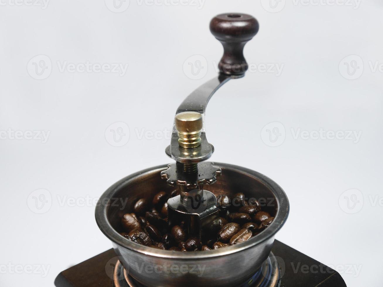 Coffee beans in the wooden coffee grinder on white background. Close-up photo