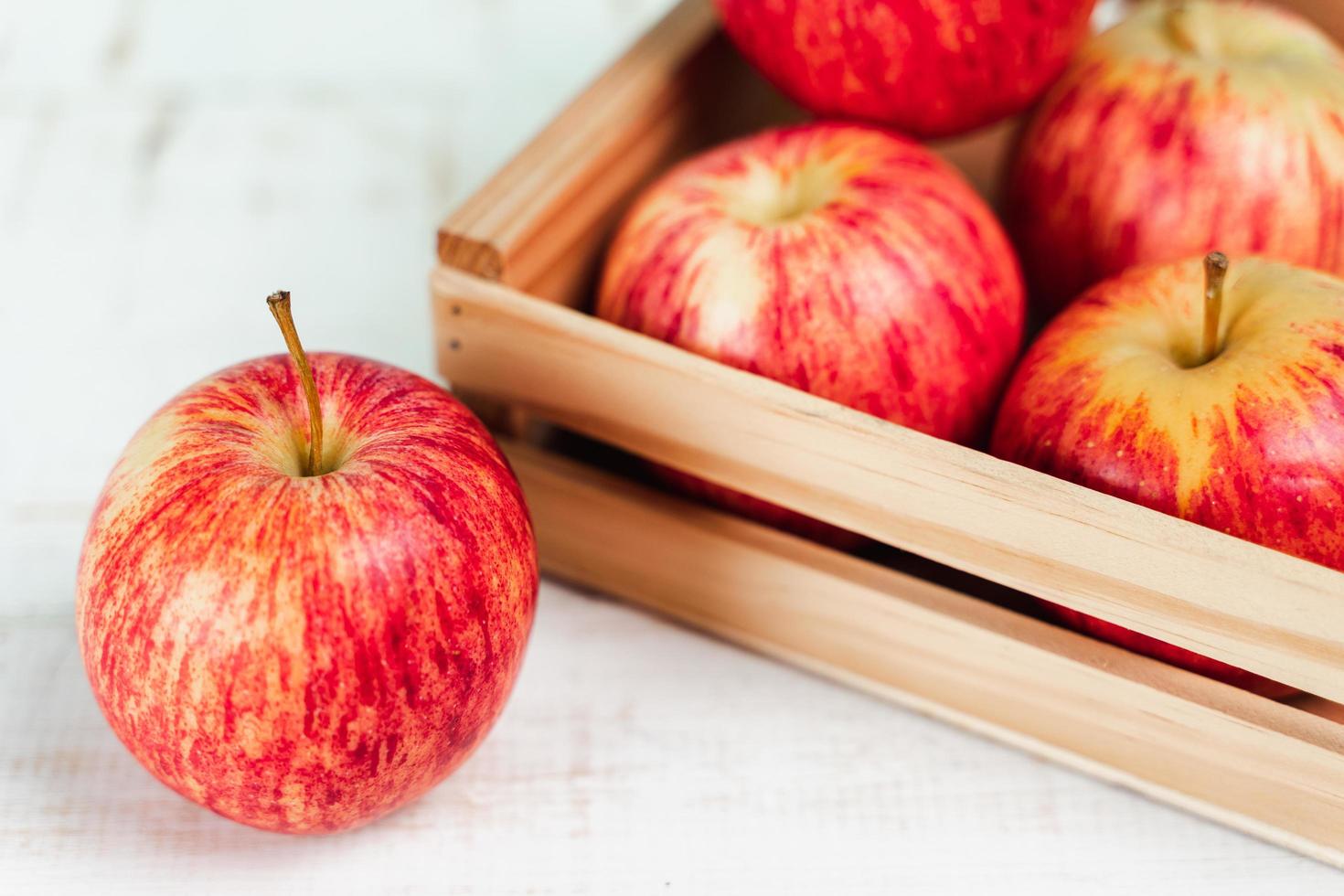 Cerca de manzanas rojas maduras frescas en una caja de madera. foto